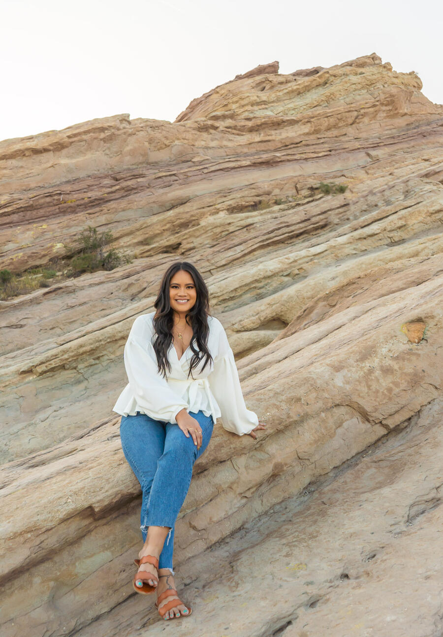 professional podcaster and event manager posing on rocks outside